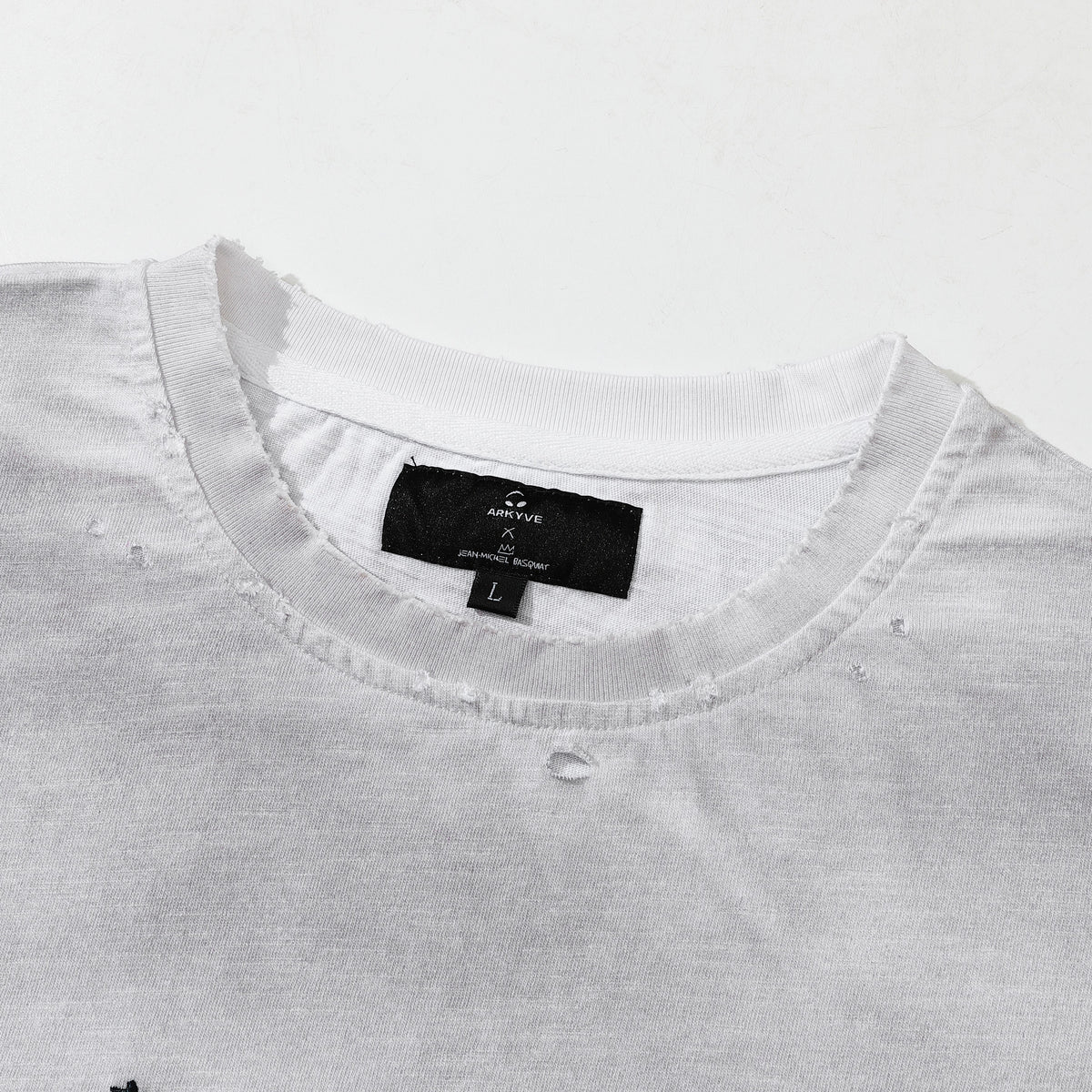 Arkyve X Basquiat Per Capita Long Sleeve in white, Arkyve x Jean-Michel Basquiat neck label